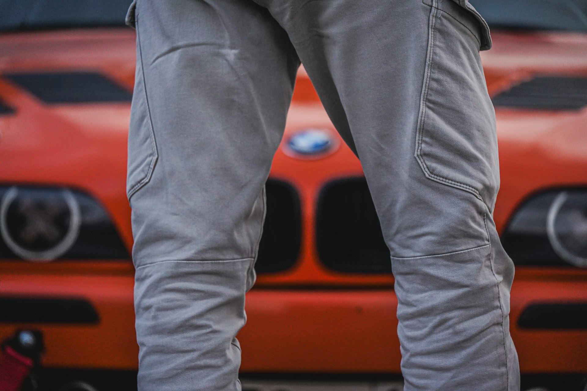 Man standing in front of an orange bmw.